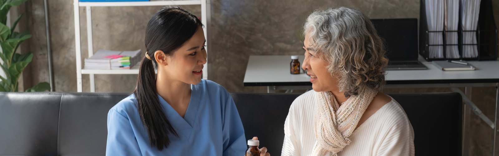 caregiver giving medicine to senior