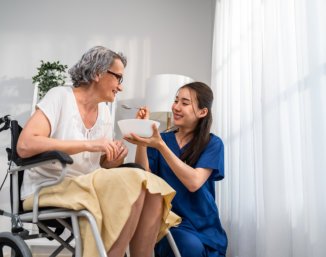 caregiver feeding senior