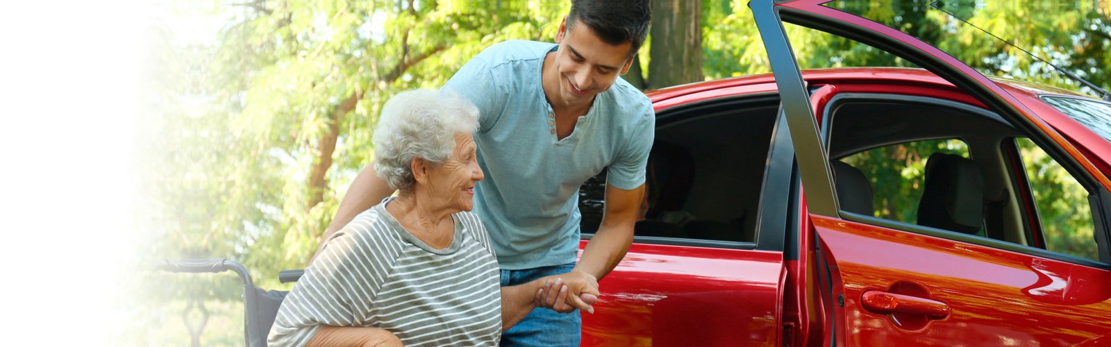 caregiver assisting senior transfer to vehicle