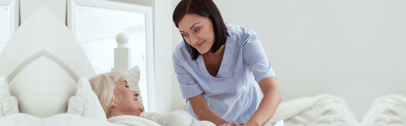 caregiver putting blanket to senior